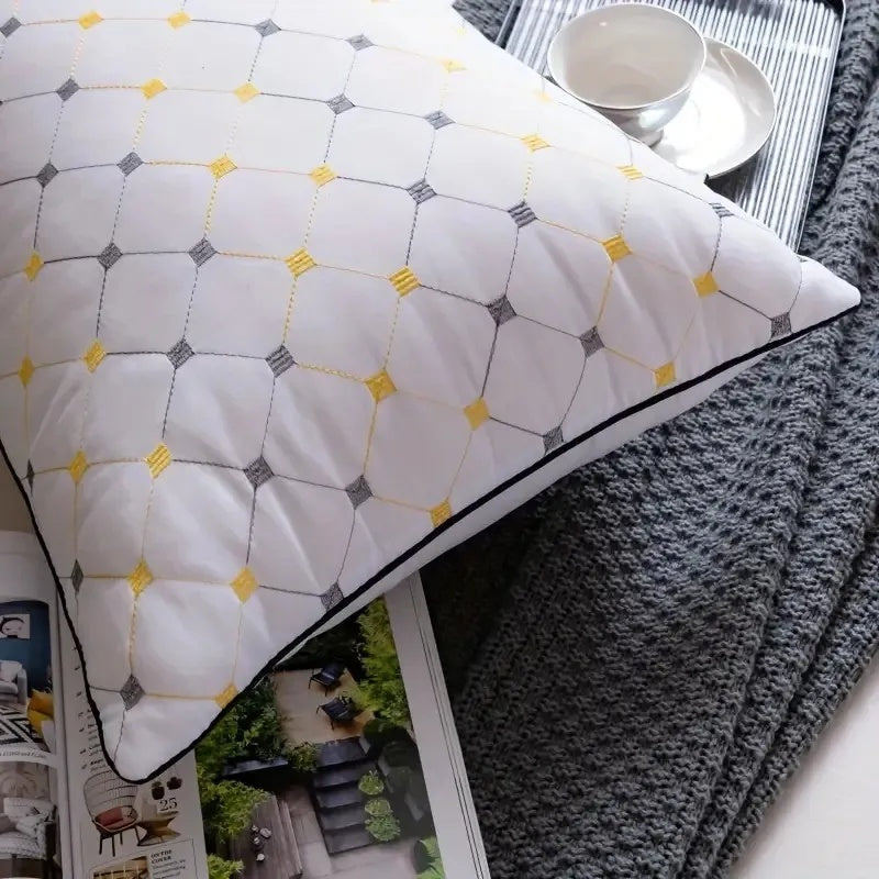 Decorative pillow with geometric pattern on a magazine and blanket